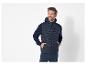 Un homme portant une veste matelassée à capuche bleu marine Le Coq Sportif.
