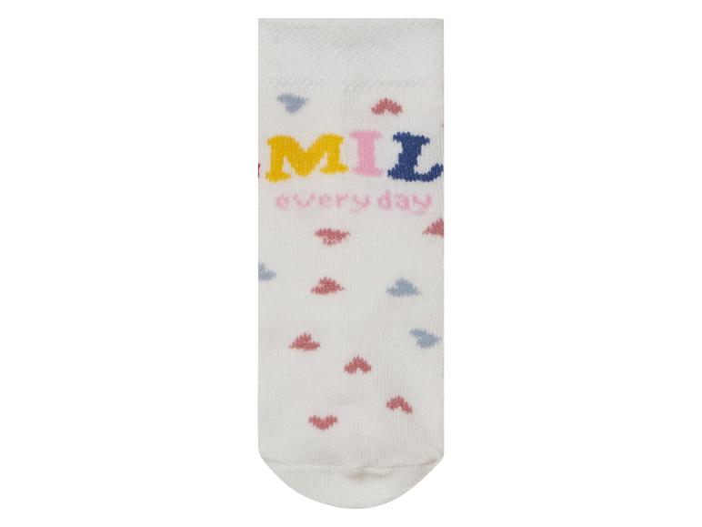 Des chaussettes blanches avec un motif coloré 'Smile every day'.