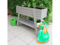 Jardinière en bois sur pieds avec arrosoir et sac de terreau.
