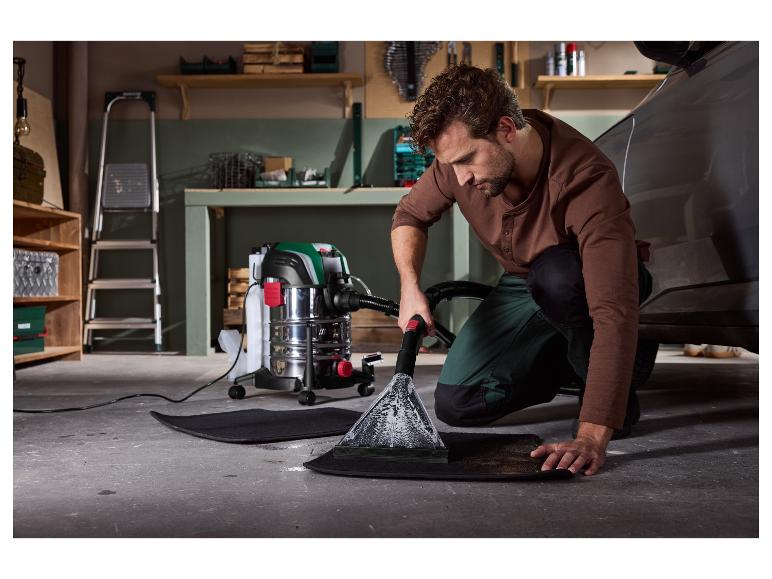 Homme nettoyant tapis de voiture avec un aspirateur eau et poussière.