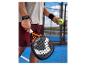 Raquette de padel et balle tenues par un joueur sur un court de padel.