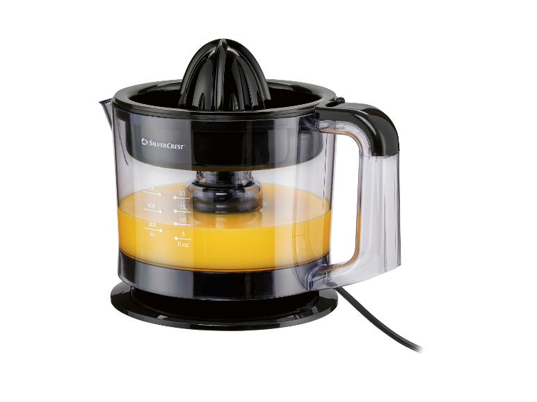 Presse-agrumes SilverCrest avec jus d'orange dans un récipient transparent.
