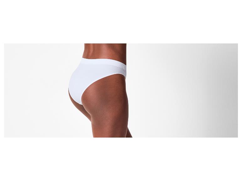 Une femme à la peau foncée porte une culotte blanche, vue de côté.