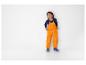 Un garçon porte un pantalon de pluie orange et des bottes bleues.