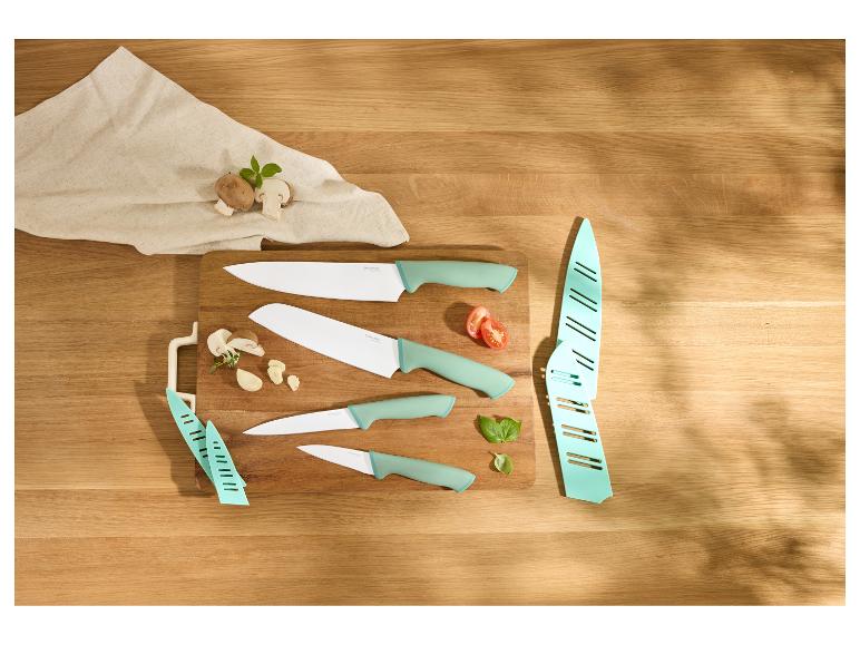 Ensemble de couteaux sur une planche à découper avec champignons, ail, tomate et basilic.