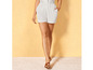 Shorts blancs et sandales marrons.
