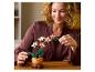 Femme souriante avec une orchidée à construire sur une table en bois.