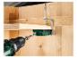 Perceuse et gabarit de perçage pour bois, fixés avec une pince