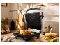 Un grill ouvert avec un sandwich grillé et un autre sandwich dans une assiette.