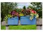 Jardinières bleues avec des fleurs colorées sur un banc en bois dans un jardin.