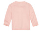 Un pull rose à manches longues en tricot.