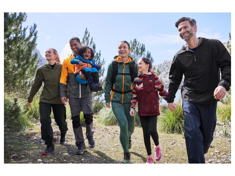 Famille heureuse faisant de la randonnée avec des vêtements de sport Decathlon.