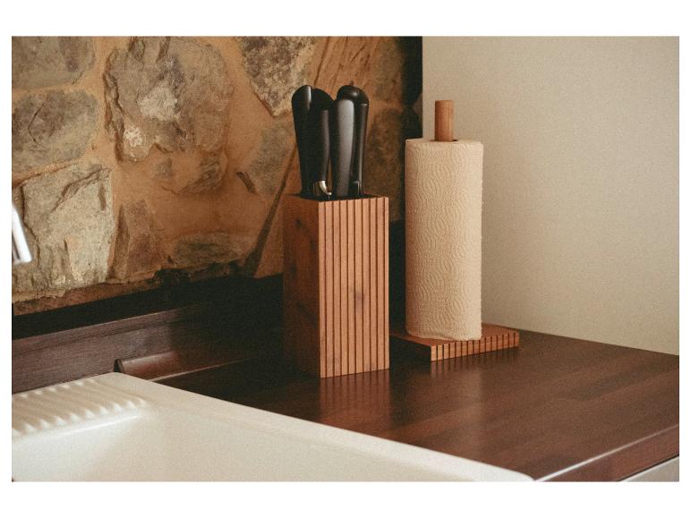 Bloc à couteaux et porte-essuie-tout en bambou sur un comptoir de cuisine.
