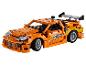 Voiture de sport orange en briques de construction avec des détails verts et gris.