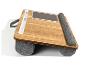 Une table d'ordinateur portable en bois avec des coussins gris.