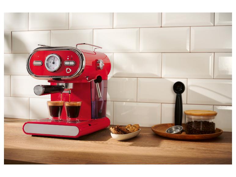 Machine à expresso rouge rétro préparant du café sur un comptoir en bois.