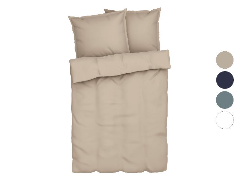 Parure de lit beige avec oreillers.