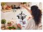 Une femme utilise un robot culinaire intelligent Monsieur Cuisine Connect pour transformer des légumes.