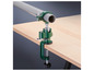 Un étau de banc vert avec un serre-tube fixé sur un dessus de table en bois.