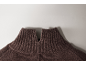 Gros plan d'un pull en maille marron avec un col montant fendu