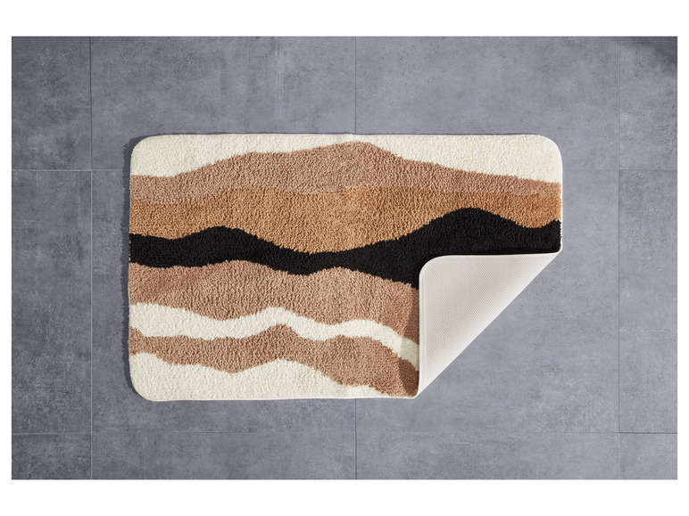 Un tapis de bain avec des rayures ondulées en beige, marron et noir.