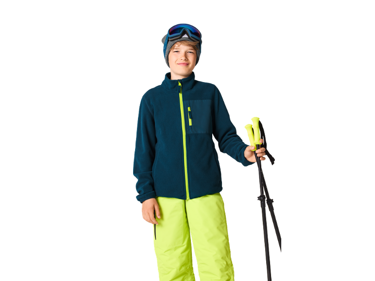 Garçon en tenue de ski avec bâtons de ski