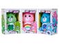 Trois peluches Care Bears emballées : Good Luck Bear, Cheer Bear et Grumpy Bear.