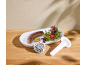 Saucisse grillée avec salade et moutarde, à côté d'un poussoir à saucisses et d'une plaque de hachoir.