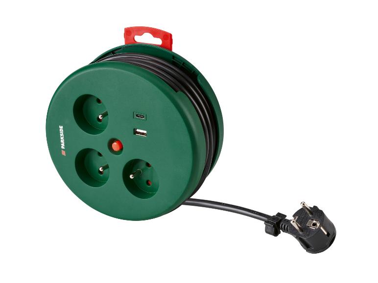 Enrouleur de câble vert avec trois prises, ports USB et une fiche.