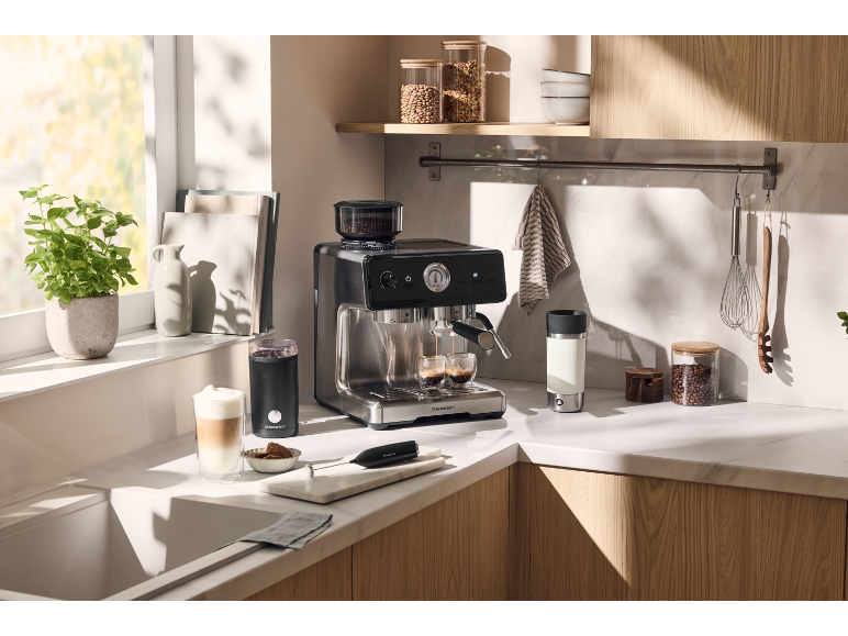 Machine à expresso et moulin à café dans une cuisine moderne et lumineuse.