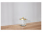 Un pot en verre avec un couvercle doré sur une table en bois.