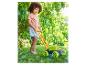 Un enfant joue avec une tondeuse à bulles dans le jardin.