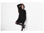Femme en robe pull noire, collants noirs et bottines noires.