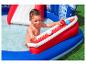 Enfant heureux jouant dans une piscine gonflable avec toboggan rouge et balles.
