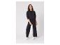 Femme en sweat-shirt noir et pantalon de survêtement large avec des baskets blanches