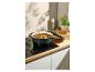 Cocotte en fonte vert foncé avec un ragoût sur une plaque à induction.