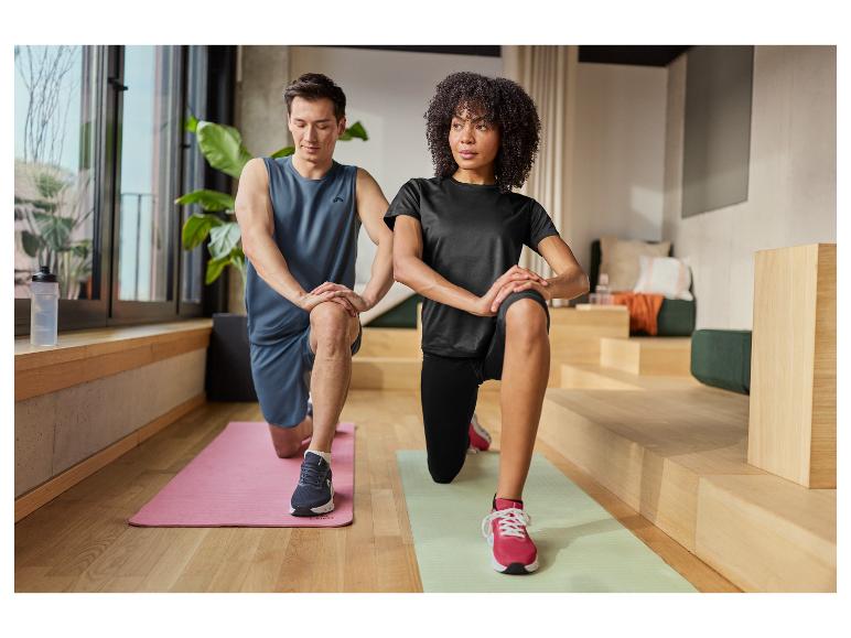 Homme et femme en tenue de sport faisant des fentes sur des tapis d'exercice.