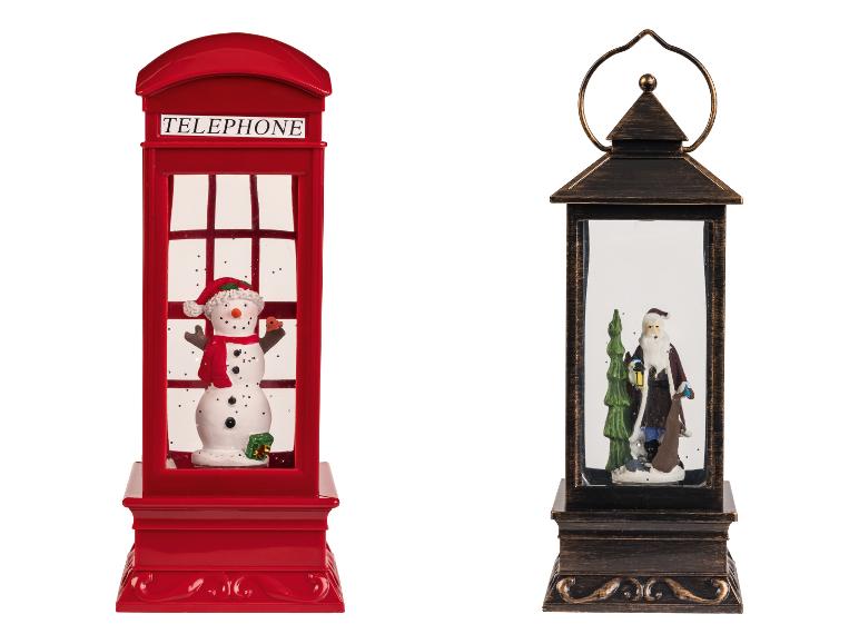Deux décorations de Noël : une cabine téléphonique rouge avec un bonhomme de neige et une lanterne avec le Père Noël.