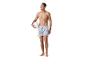 Homme en maillot de bain rayé tenant un ballon de volley.