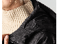 Gros plan d'une femme portant une veste noire à capuche et un pull en maille.