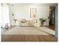 Salon moderne avec canapé beige, tapis clair et décoration minimaliste.