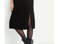 Pull noir avec fente et bottes noires.