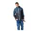 Homme en veste outdoor bleu-gris et jean, tenant des bâtons de randonnée.