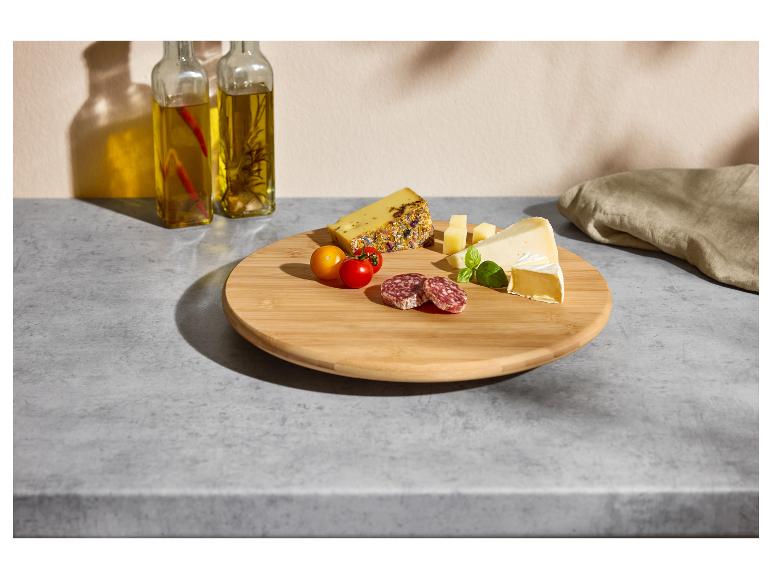 Planche de service avec fromage, salami, tomates cerises et huile.