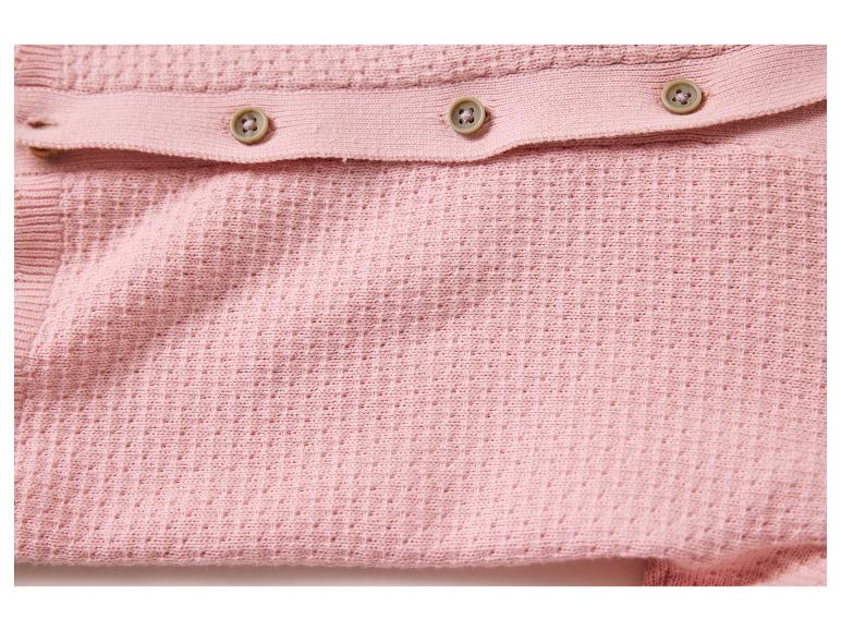 Gros plan sur un tissu de coton rose tricoté avec des boutons.