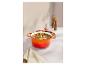 Cocotte en fonte émaillée orange remplie de ragoût, avec des moulins à sel et à poivre.