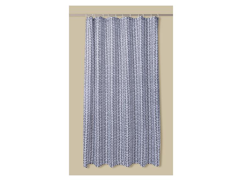 Rideau de douche blanc à motif chevron noir, suspendu à une tringle métallique.