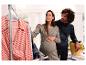 Une femme enceinte et son partenaire choisissent des vêtements pour leur bébé.