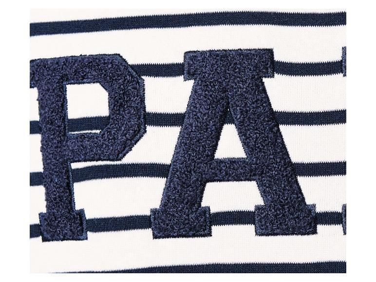 Un détail d'un t-shirt blanc à rayures avec les lettres 'PA' en bleu foncé