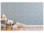 Chambre d'enfant avec papier peint étoiles, table de chevet en bois et jouets en peluche.